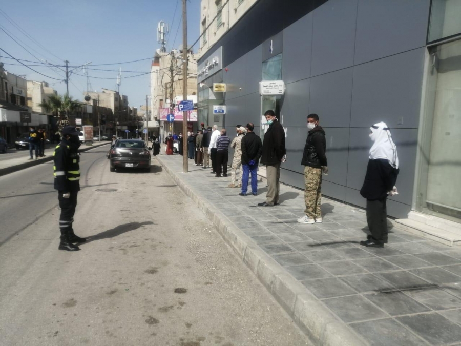 رجال الامن العام ينظمون الاصطفاف والدور امام فروع البنوك... صور