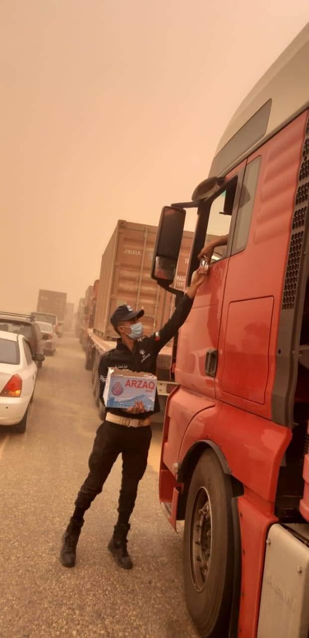 الأمن العام يوزعون المياه على المواطنين في  الطريق الصحراوي