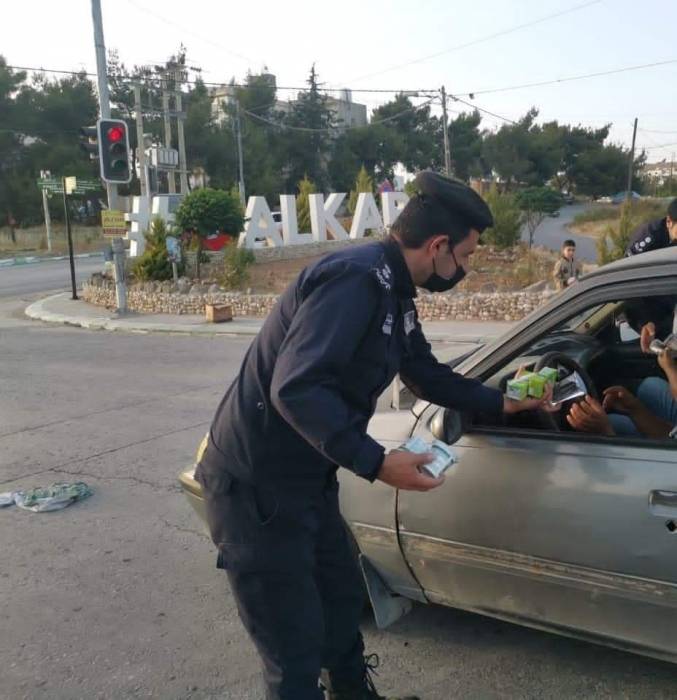 الشرطة المجتمعية توزع التمر والماء على المواطنين في الطريق العام بالكرك