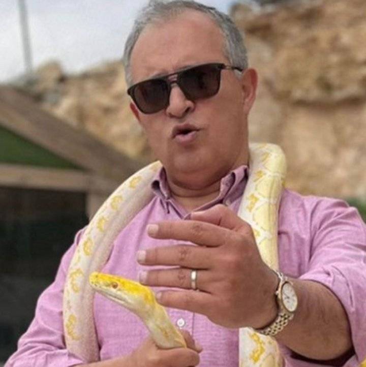 القطامين يحذر من الأفاعي حاملا إحداها