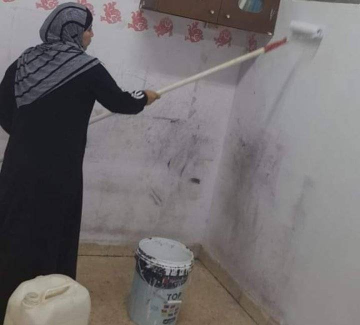 المعلمة صفاء ابو مرشود ترسم الابتسامة لطلابها في الصف الأول