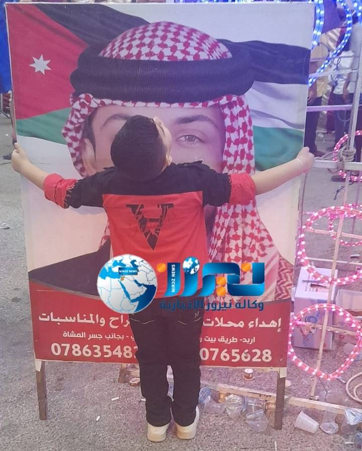 بالصور ..الطفل محمد عزام الحوري يحتضن صورتين لولي العهد