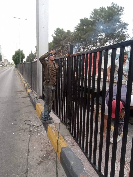 بلدية اربد الكبرى تجري صيانة للسياج الحديدي الواقع امام البوابة الشرقية لمدينة الحسن الرياضية