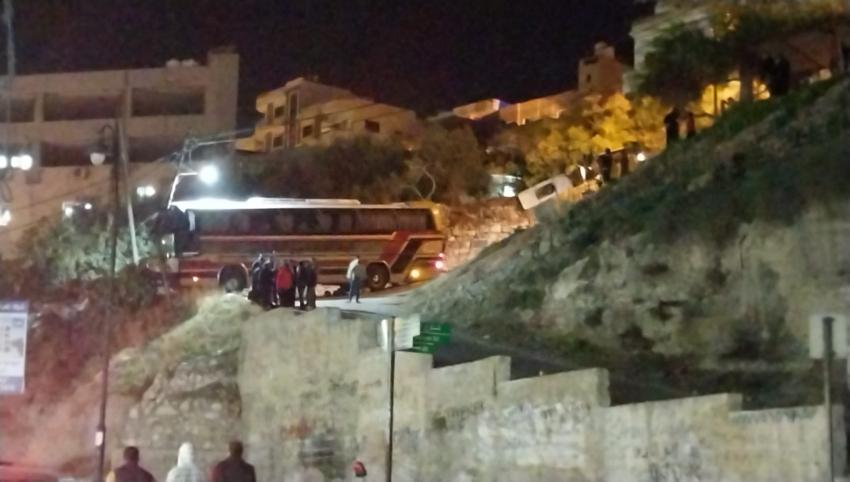 عاجل ...حافلة سياح تعلق بطريق ضيق في جرش ..صور