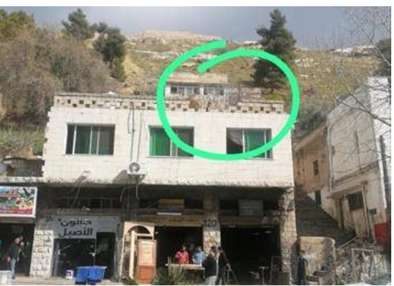 سقوط صخرة كبيرة يتسبب بانهيار جزء من جدار لمبنى بالسلط