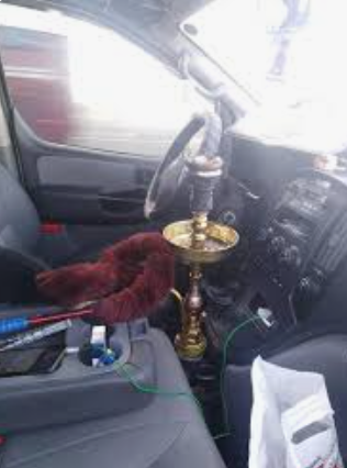 استهتار السائقين يتواصل.. ضبط سائق يدخن الارجيلة في شارع حيوي