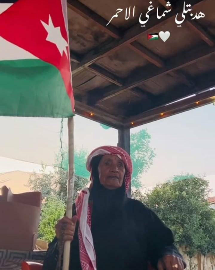 تعبيرًا عن فرحتها بعيد الاستقلال ال77..الحاجة أم عوض الكعابنة ترفع العلم الاردني عاليا