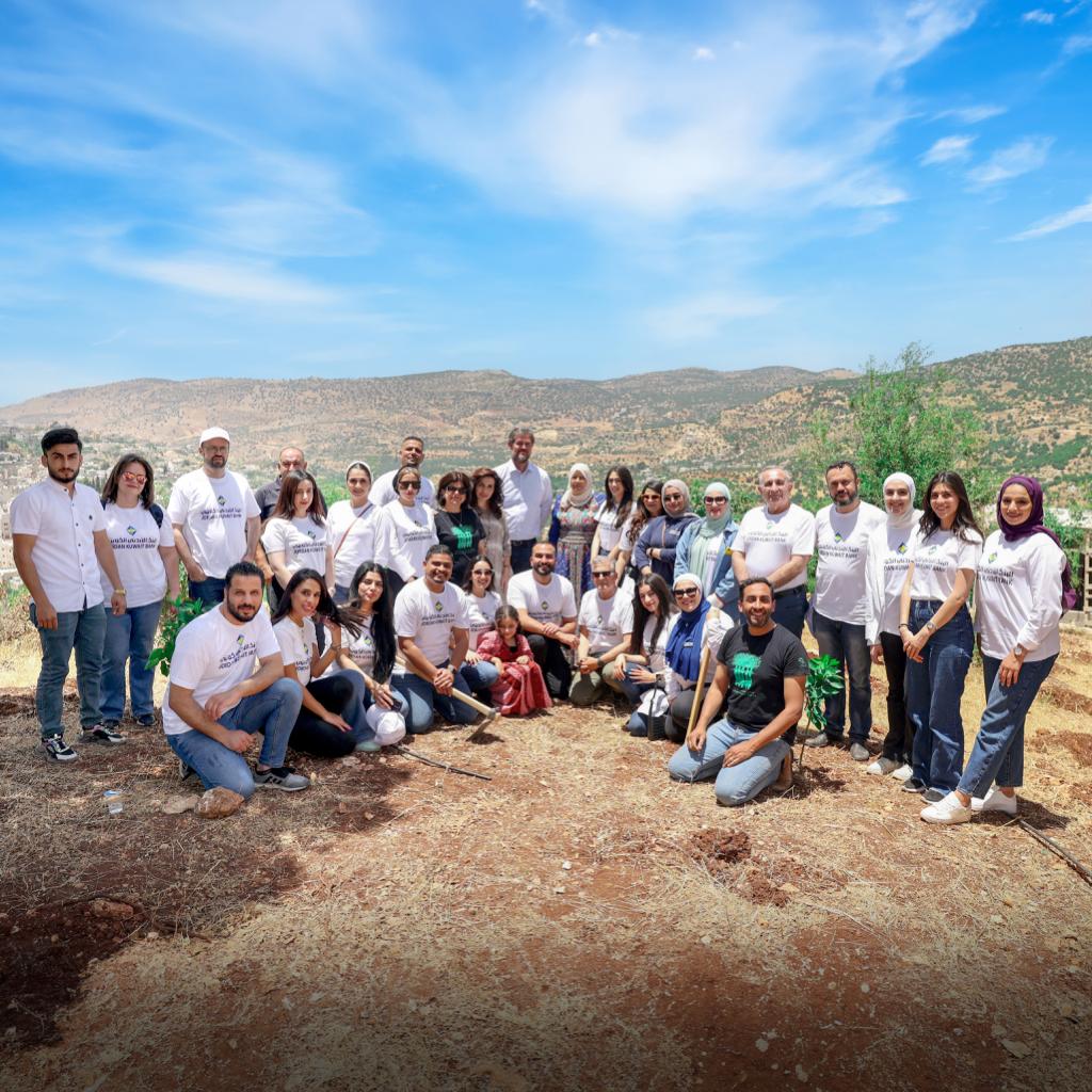 موظفو الأردني الكويتي يشاركون في القافلة الخضراء لزراعة 500 شجرة في عجلون