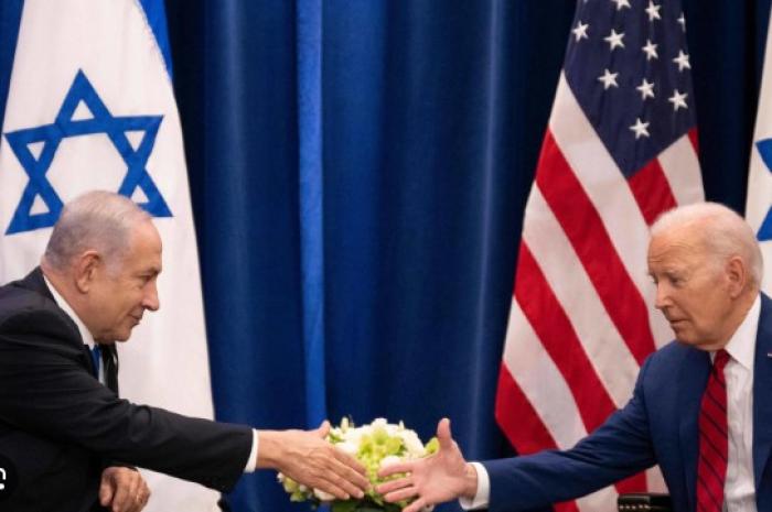 طفل يمني يضع صورة بايدن ونتنياهو على ميزان